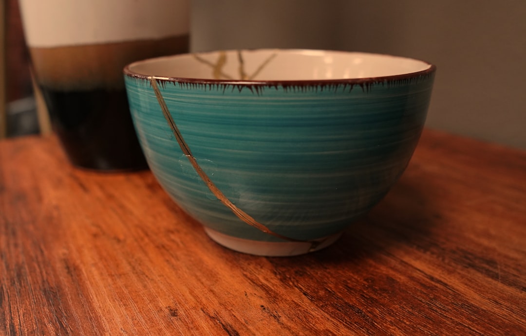 A beautifully repaired piece of pottery with gold seams, illustrating the concept of Kintsugi, where brokenness is mended to create something stronger and more beautiful, symbolizing healing and resilience.