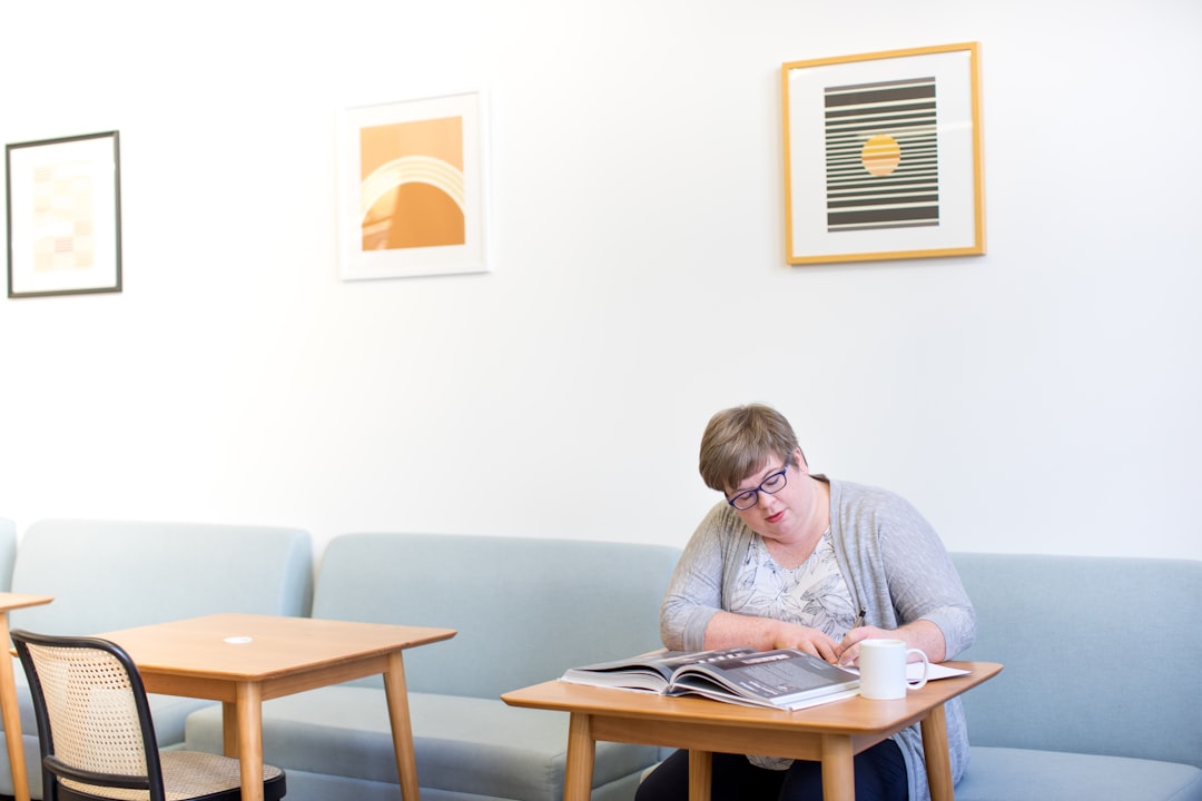 Two people sit at a bright, modern table calmly discussing documents, illustrating the clarity and guidance offered for complex real estate financial decisions.